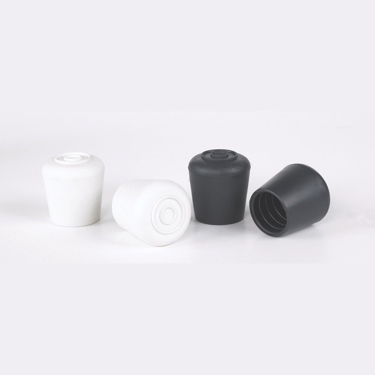 Black and white rubber sleek pole caps side by side, cylindrical shape with rounded tops—designed to fit 1″ flag poles with smooth, snag-free ends for aesthetic performance