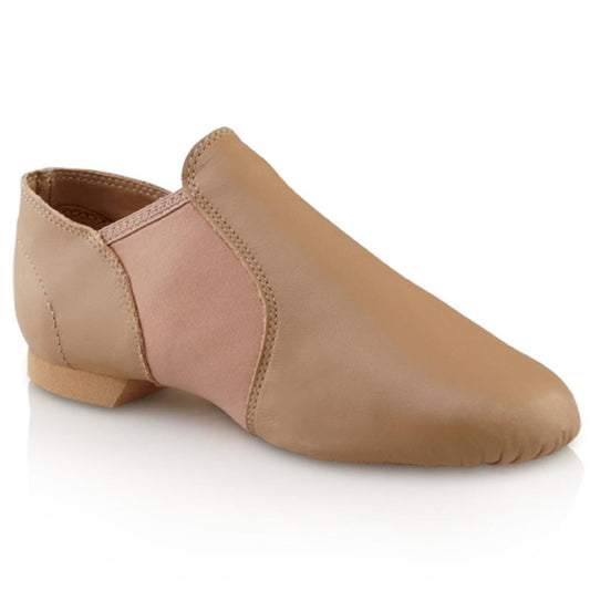 Capezio E‑Series Jazz slip‑on in tan leather showing split‑sole flexibility, elastic insets, cotton lining, and low-profile heel for smooth transitions.