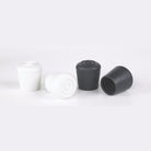 Black and white rubber sleek pole caps side by side, cylindrical shape with rounded tops—designed to fit 1″ flag poles with smooth, snag-free ends for aesthetic performance