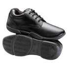 Super Drillmasters marching shoe in black full‑grain leather with lace‑up oxford styling, padded collar, cushioned tongue, and reinforced eyelets for durability during performances. Sole view of Super Drillmasters shoe featuring non‑marking rubber outsole with pivot disc, shallow flex grooves, and shallow tread pattern designed for grip on turf and gym surfaces.